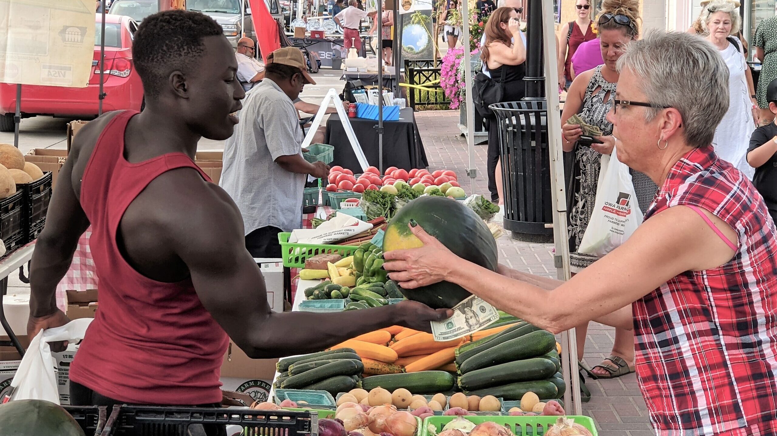 Valley Junction Farmers Market woman buying a watermelon